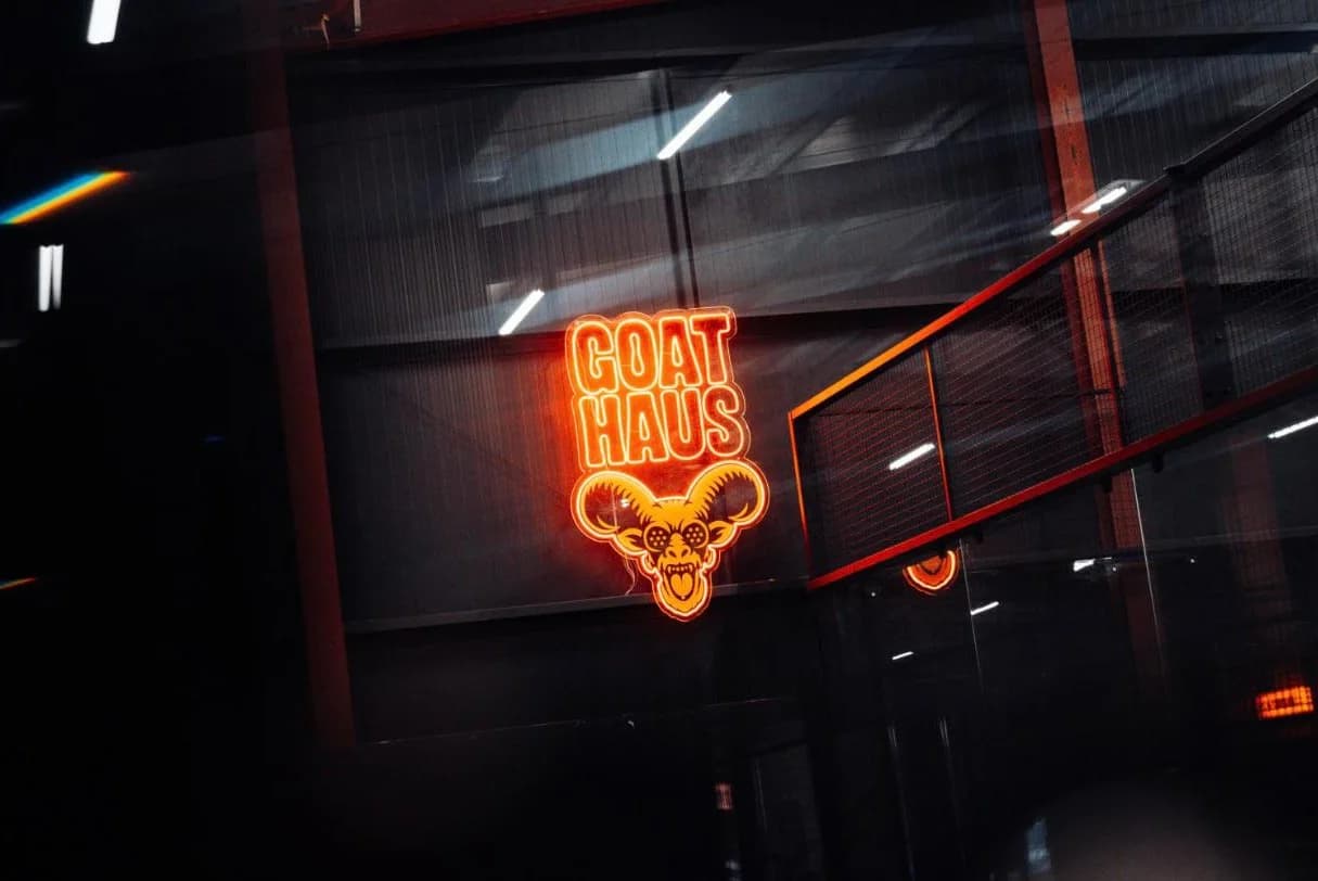 The neon Goat Haus sign glowing inside the padel club