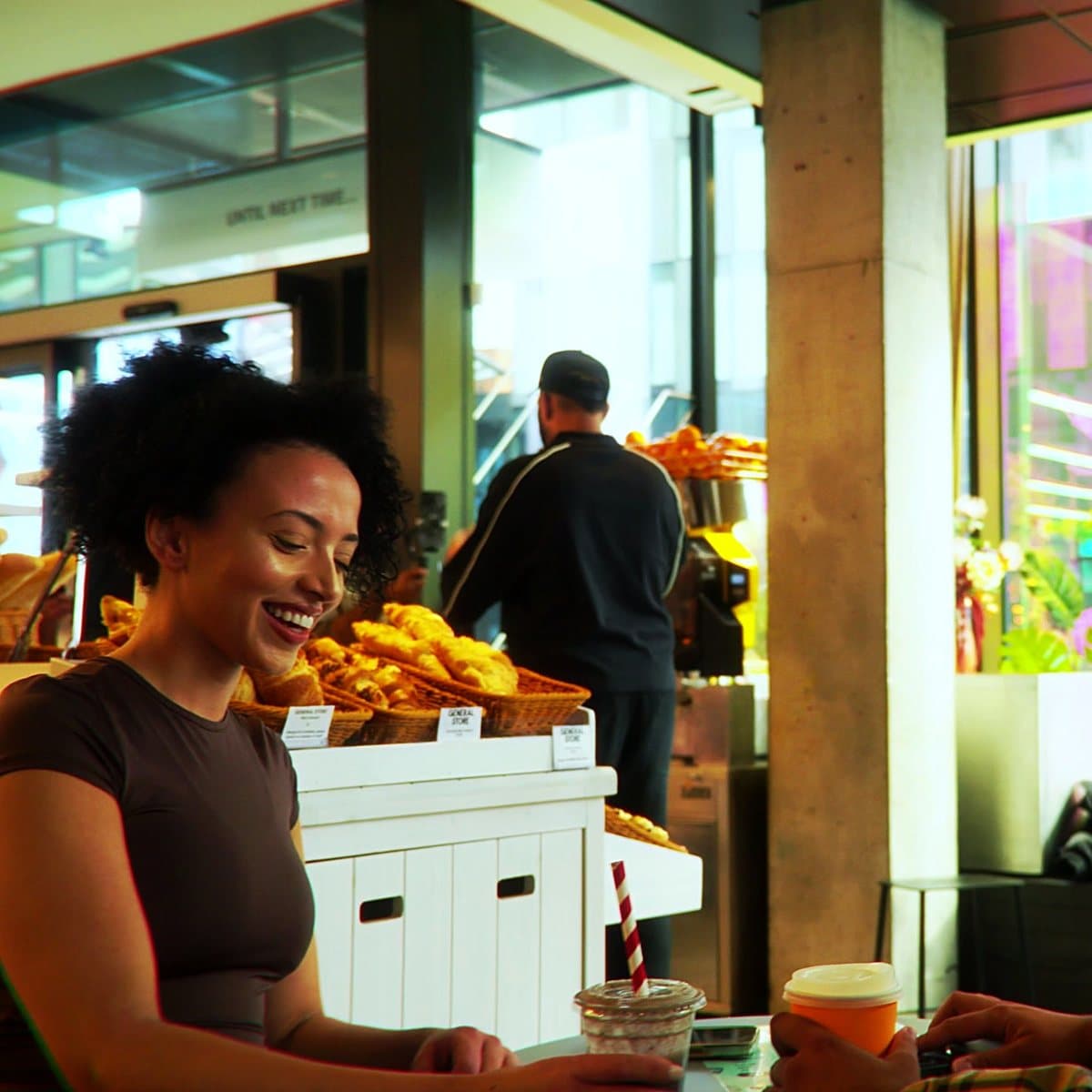 Two people laughing over coffee at the Sipp counter