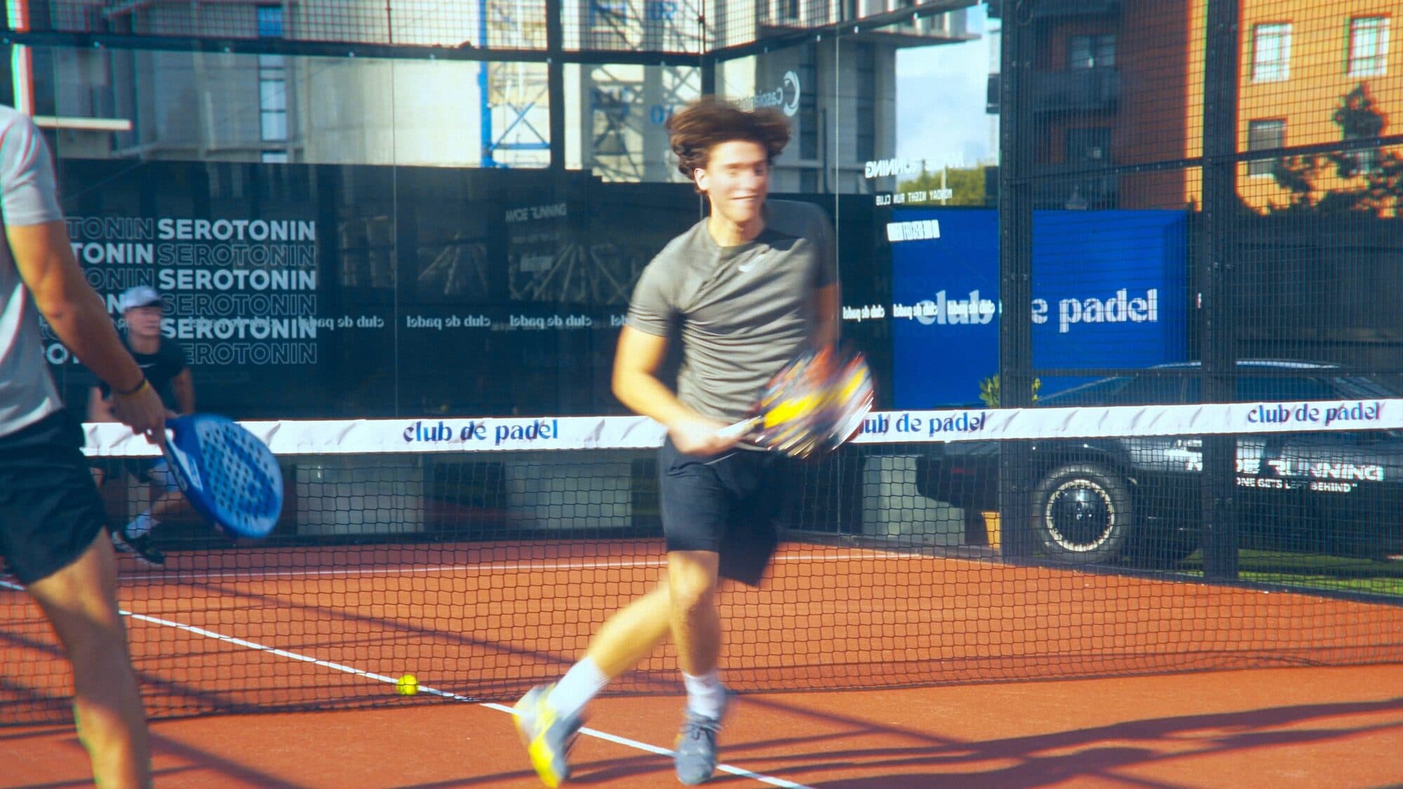 Players mid-rally on a red Club de Padel court